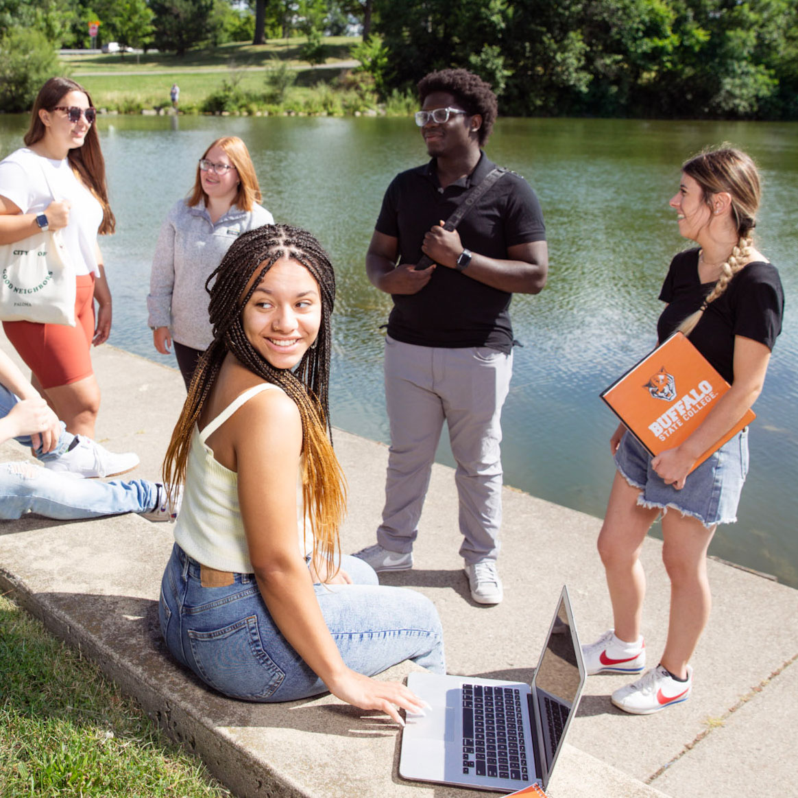 Group of students talking in the park with notebooks and study materials
